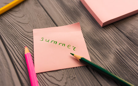 artist multicolored pencils sketch paper card inscription summer. Yellow red blue pencils. Summer background template mockup space blank colorful composition text. Top view above wooden backgroundの写真素材