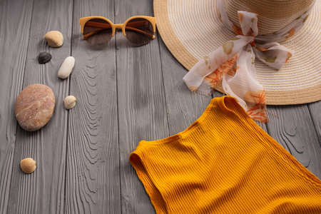 beachwear orange woman top outfit hat bag sun protection sunglasses pebbles. Summer background template mockup free space composition sample text. Top view above wooden background vacation conceptの写真素材