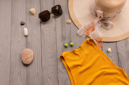 beachwear orange woman top outfit hat bag sun protection sunglasses pebbles. Summer background template mockup free space composition sample text. Top view above wooden background vacation conceptの写真素材