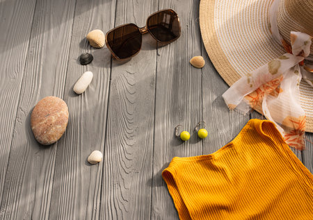 beachwear orange woman top outfit hat bag sun protection sunglasses pebbles. Summer background template mockup free space composition sample text. Top view above wooden background vacation conceptの写真素材