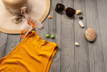 beachwear orange woman top outfit hat bag sun protection sunglasses pebbles. Summer background template mockup free space composition sample text. Top view above wooden background vacation conceptの写真素材