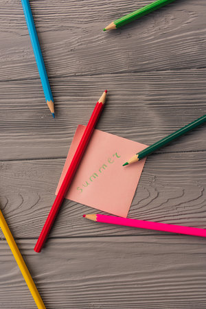 artist multicolored pencils sketch paper card inscription summer. Yellow red blue pencils. Summer background template mockup space blank colorful composition text. Top view above wooden backgroundの写真素材