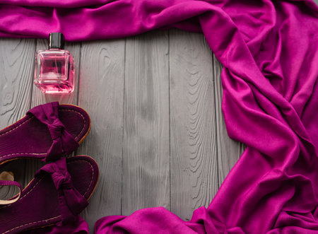 burgundy sandals wedge shawl shoes and bottle pink perfume. Summer background template mockup copy free space pattern colorful composition sample text. Top view above grey wooden background flat layの写真素材