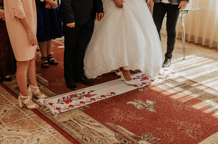 The bride and groom take a step on white national towels. Ukrainian national ornament embroidered.の写真素材