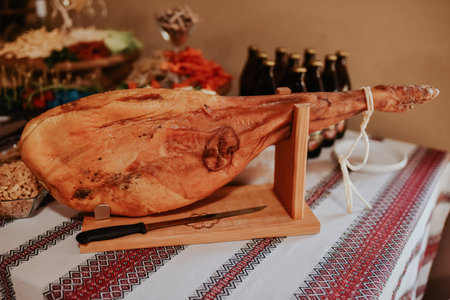 Spanish ham, Jamon Serrano, Bellota Italian.Prosciutto Crudo or Parma ham, whole leg. Italy, food. a large piece of Italian.Parma ham hanging from a hook. prosciutto leg hangs on table in display caseの写真素材