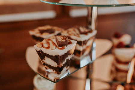 stylish desserts with strawberry, candy bar with sweets at luxury wedding reception. catering at restaurant. cupcakes macaroons on table. space for text. cakes, strawberry tartlet, cupcakes macaronsの写真素材