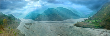 panorama of the wide watercourse river with mountain ranges in the middle. Uttarakhand, Haidakhan,...