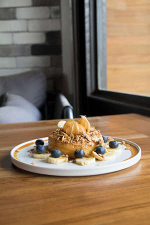 Close Up Shot Donut Cake with Granola Banana and Berry on top with Orangeの写真素材