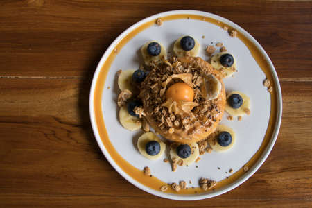 Overhead Shot Cake with Peanut Butter on top with Granola Banana and Berry on Wooden Tableの写真素材