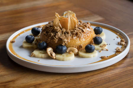 Peanut Butter Cake On top with Granola Banana and Berry on Wooden Tableの写真素材