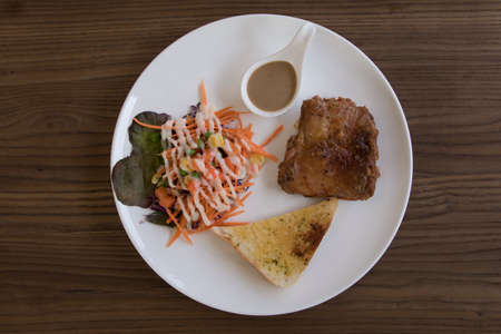Chicken Steak with salad overhead shot on wooden tableの写真素材