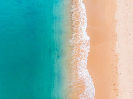 Aerial view of beach and blue ocean with waves reaching shoreの写真素材
