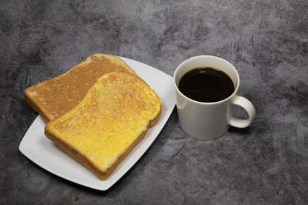 Butter bread with black coffee on concrete backgroundの写真素材