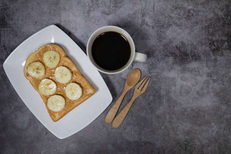 Coffee with banana bread and butter bread on concrete background. top viewの写真素材