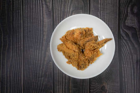 Delicious crispy fried chicken on white plate set on wooden background. Top viewの写真素材