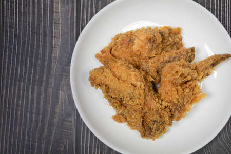 Deep fried chicken on white plate set on wooden background. close upの写真素材