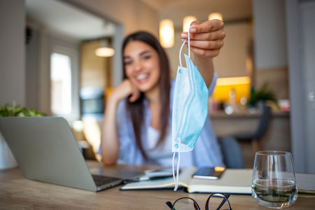 Smiling young businesswoman working on laptop at home