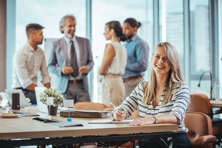 Portrait of a smiling young businesswoman sitting at a table in the office