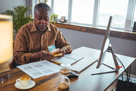 Mature african american businessman working on computer at office deskの写真素材