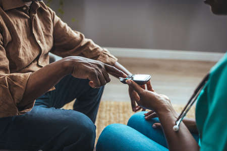 Close-up of a healthcare professional checking a patient's blood sugar levels.の写真素材