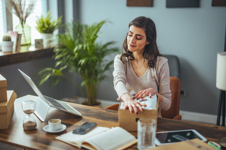 Young businesswoman working at home office with laptop and coffee cup.