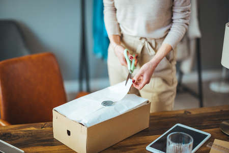 Woman packing box for delivery to customer. Delivery service, online shopping conceptの写真素材
