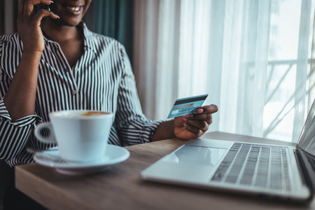 Cropped image of african american woman using credit card and laptop for online shopping
