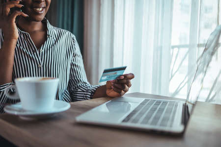 Cropped image of african american man using credit card and laptop for online shoppingの写真素材