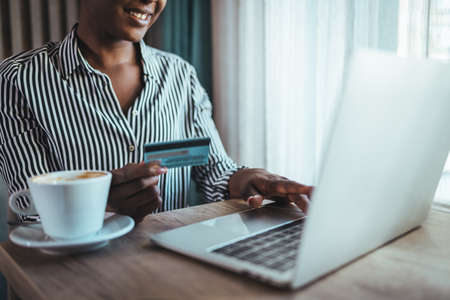 Cropped image of african american woman using laptop and credit card for online shoppingの写真素材