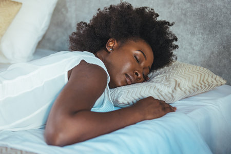 Young african american woman sleeping on the bed at home.