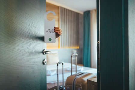 Woman's hand opening hotel room door.の写真素材