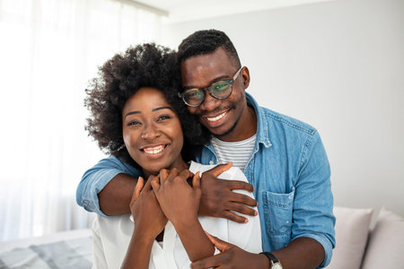 Happy african american couple in eyeglasses hugging at home