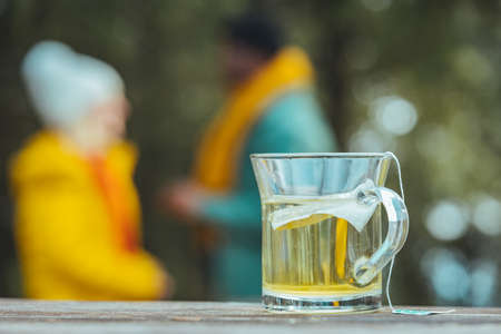 A glass of hot tea on a wooden table in the park.の写真素材