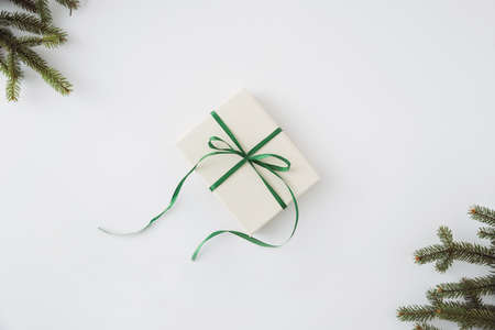 Homemade gift with bow white background and conifer brunches in corners flat lay do it yourselfの写真素材