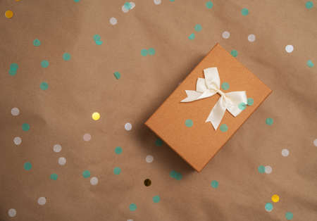 Celebration party with confetti and wrapped gift box with natural colors flat layの写真素材