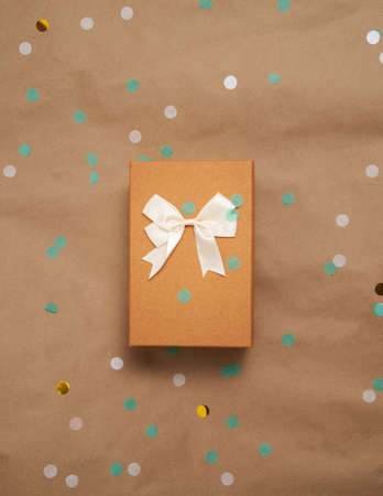 Celebration party with confetti and wrapped gift box with natural colors flat layの写真素材
