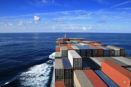 Blue sky and container ship underwayの写真素材