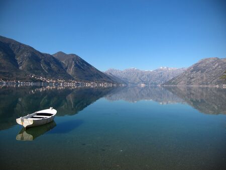 Fishing boat tied to a buoy. Calm water and nice blue sky in the backgroundの写真素材