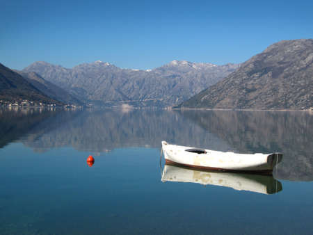 Fishing boat tied to a buoy. Calm water and nice blue sky in the backgroundの写真素材