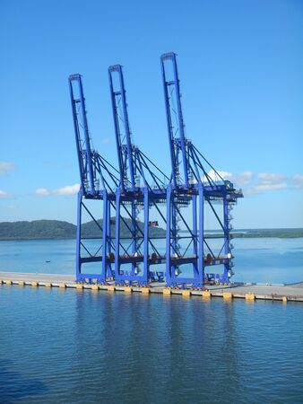 Narrow pier and container gantries with nice blue sky in the backgroundの写真素材