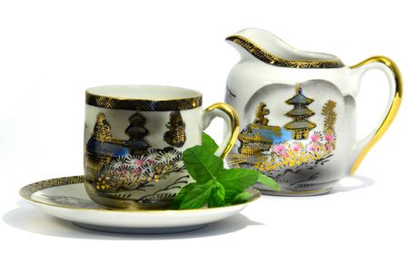 Handmade and decorated tea cup and milk pot isolated on white background.の写真素材