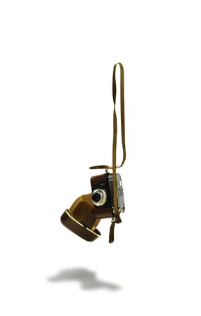 Old photo-camerra falling down. Camera is isolated on white background. Camera used with open protective case.の写真素材