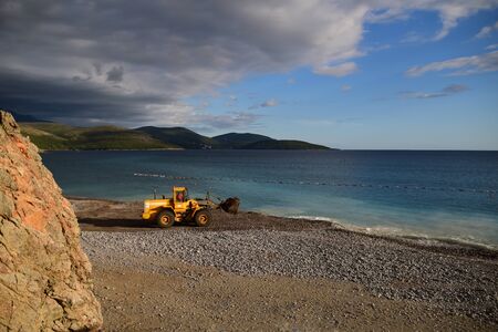 Digger working on the beach, polluting the water. Action shoot. Photo taken in Lustica Bay, Montenegro.の写真素材