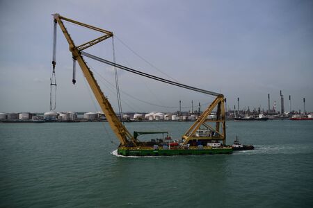 Floating crane being escorted by a tug boat. Photo taken in Singapore.のeditorial素材