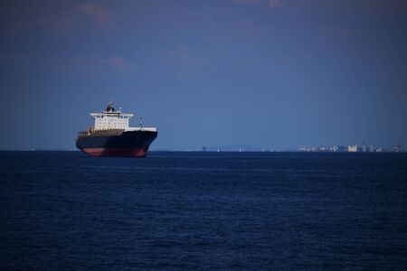 Large container vessel at the anchorage near the port. Blue sky in the background.の写真素材