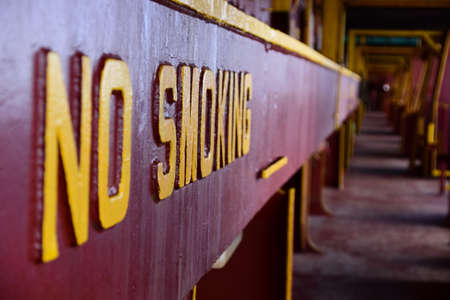 No smoking sign welded on a side of hatch coaming. Visible is main deck on container vessel.の写真素材