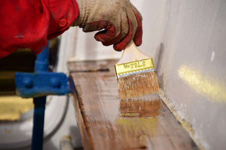Maintenance of wooden surface on a ship requires several layers of varnish to be applied.の写真素材