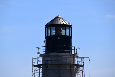 Building a new light tower at the entrance to the luxury marina. Tower is surrounded with stage or scaffoldings.の写真素材