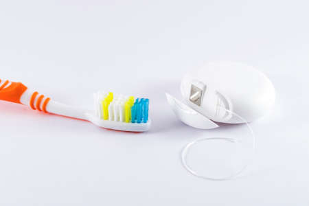 Toothbrush and dental floss on white backgroundの写真素材