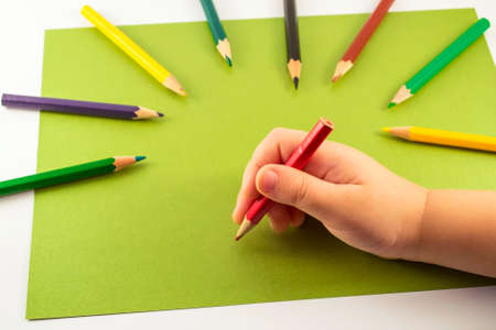 Kids hand holding a red pencilの写真素材